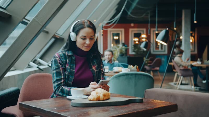 Client attablé à la terrasse d'un café répondant à une courte enquête sur son smartphone