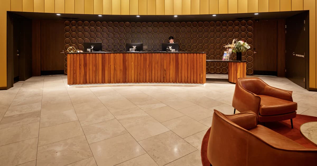 Hotel receptionist viewing a unified guest profile on a monitor
